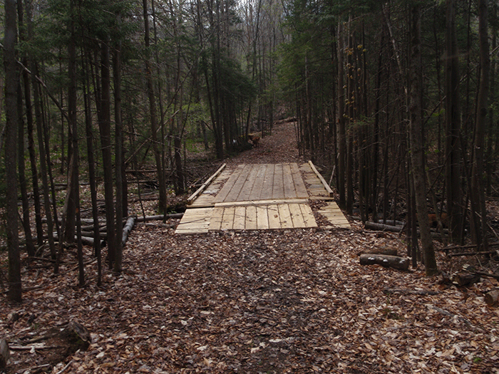 The Seventh Lake Mountain Trail, a class II community connector snowmobile trail,  includes dozens of large 12-ffot-wide bridges to support multi-ton groomers. This is a design feature that is not used for foot trails.