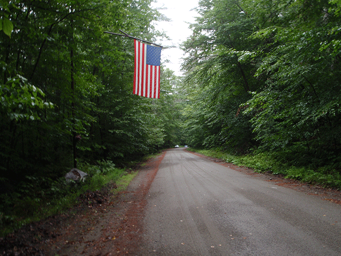A large flag hangs over the end of the Crane Pond Road, where it transitions from a Town of Schroon Road to part of the Forest Preserve Road. Located in a Wilderness Area, a Unit Management Plan stated in 1992 that Crane Pond Road should be closed, but it remains open. 