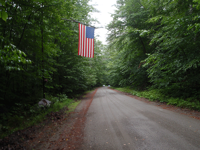 A large flag hangs over the end of the Crane Pond Road, where it transitions from a Town of Schroon Road to part of the Forest Preserve Road. Located in a Wilderness Area, a Unit Management Plan stated in 1992 that Crane Pond Road should be closed, but it remains open.